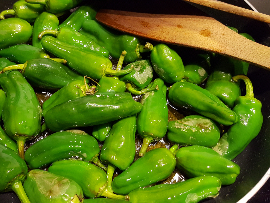 Grüne Brat-Paprika mit frischem Knoblauch in Öl